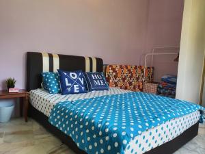 a bedroom with a bed with blue and white sheets at Homey Homestay in Tanjong Sepat