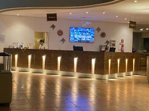 un vestíbulo con un bar con luces encendidas en Flat Beach Class Resort Muro Alto en Porto De Galinhas