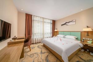 a hotel room with a large bed and a desk at Guangzhou Boyi Hotel in Guangzhou