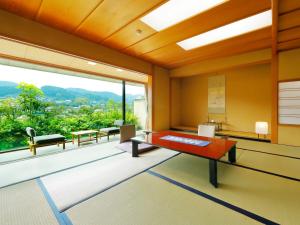 a living room with a table and a large window at Taishoya in Ureshino
