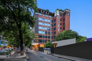 une rue de la ville avec un grand bâtiment en arrière-plan dans l'établissement Guangzhou Boyi Hotel, à Canton