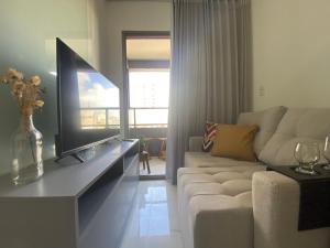 sala de estar con sofá y TV de pantalla plana en AlahMar - Conforto na Praia, en Salvador