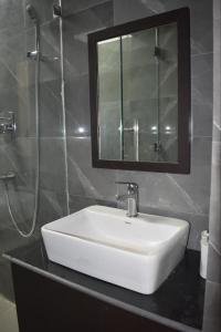 bagno con lavandino bianco e doccia di The White Lotus a Gaya