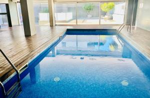 a swimming pool with blue water in a building at Beach & Culture Barcelona Port Forum Penthouse Apartment in Sant Adria de Besos