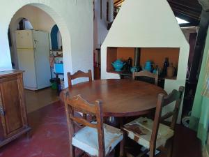 comedor con mesa de madera y sillas en Casa Soleares en Villa Las Rosas