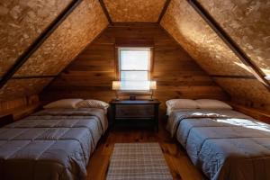 2 bedden in een zolderkamer met een raam bij Elk Mountain Ski Resort: Home on 21 Acres in Union Dale