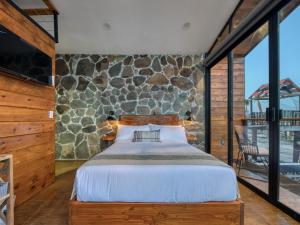a bedroom with a bed and a stone wall at Sirius Valle in Valle de Guadalupe