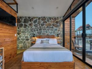 a bedroom with a bed and a stone wall at Sirius Valle in Valle de Guadalupe +71 photos
