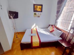 uma pequena cama num quarto com uma janela em Minh Hiền Hotel em Vung Tau