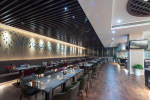 a dining room with long tables and chairs at Jin Jiang West Capital International Hotel in Xi'an