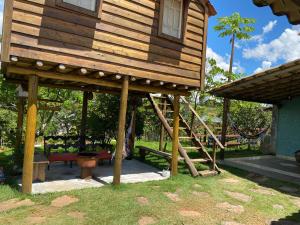 ein großes Holzhaus mit einer Veranda und einer Treppe in der Unterkunft Recanto da Represa Carrancas in Carrancas