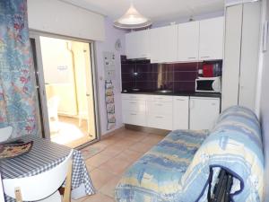 cocina con sofá y mesa en una habitación en Appartement Marseillan-Plage, 2 pièces, 4 personnes - FR-1-326-599, en Marseillan