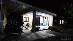 a house at night with a motorcycle parked in front of it at Polkesyo Homestay Jogja in Sleman