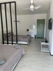 um quarto com duas camas e uma tv nele em Casa Lena em Cherating