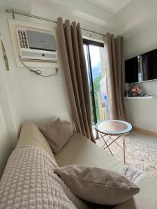 a bedroom with a couch and a tv on the wall at GZ Studio unit- Camella Northpoint in Davao City