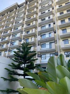 a tall building with a palm tree in front of it at GZ Studio unit- Camella Northpoint in Davao City