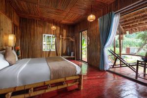 - une chambre avec un lit dans une pièce dotée de murs en bois dans l'établissement An's Eco Garden Resort, à Ninh Binh