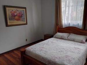 - une chambre dotée d'un lit avec une photo sur le mur dans l'établissement La Casa del Barrio La Granja, San Pedro, à San Pedro
