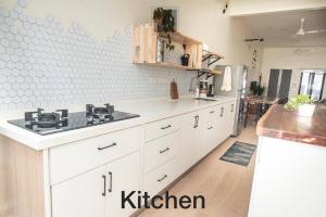 a kitchen with white cabinets and a stove in it at M12 Homestay, Butterworth in Butterworth