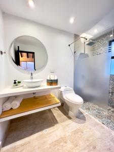 a bathroom with a sink and a toilet and a mirror at Estudia y trabaja sin límites en Hacienda Loretto con Starlink!! in Silvania