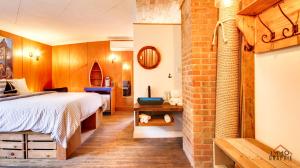 - une chambre avec un lit et un mur en briques dans l'établissement Maison Cadorette, à Saint-Jean-des Piles