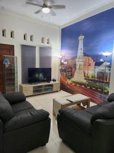sala de estar con 2 sofás y TV en INEZ Homestay Prawirotaman Yogya en Timuran