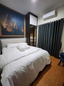 Un dormitorio con una gran cama blanca y una ventana en INEZ Homestay Prawirotaman Yogya en Timuran
