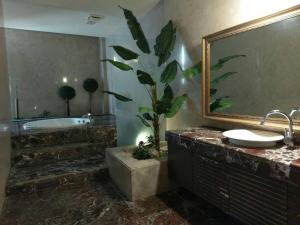 baño con bañera, lavamanos y planta en 金利星精品旅館, en Nan-p'ing