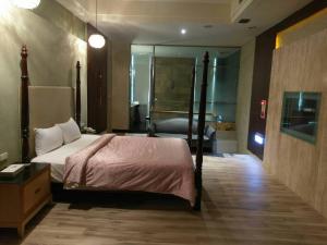 um quarto de hotel com uma cama e uma casa de banho em 金利星精品旅館 em Nan-p'ing