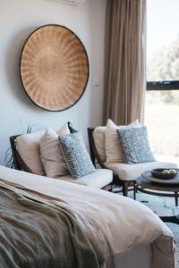 a bedroom with a bed and two chairs and a window at Majuba Country Lodge in Kalgan