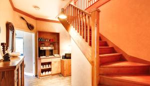 a staircase in a home with a kitchen with a microwave at Maison Cadorette in Saint-Jean-des Piles