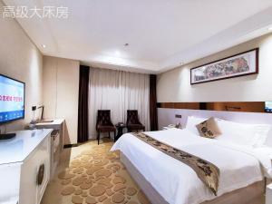 a hotel room with a bed and a flat screen tv at Paco Hotel Tianhe Couch Terminal Metro Guangzhou in Guangzhou