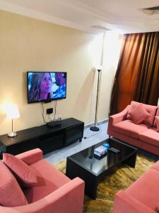 a living room with red furniture and a flat screen tv at شقق رهف السالميه in Kuwait