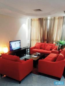 a living room with two red couches and a television at شقق رهف السالميه in Kuwait