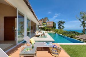 a patio with a table and chairs next to a swimming pool at Tropical Seaview Villa with Pool in Koh Samui 