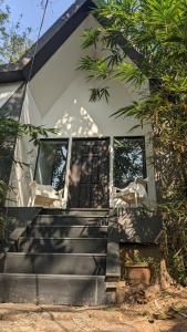ein Haus mit einer Treppe, die zur Eingangstür führt in der Unterkunft Misty Ghats Resort in Wayanad