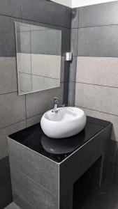 瓦亞納德的住宿－Misty Ghats Resort，浴室内黑色柜台上的白色水槽