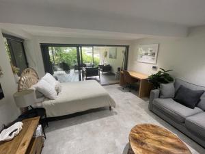 a bedroom with a bed and a couch and a table at Quiet private getaway, private gym walk 2 beach in Terrigal