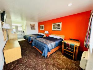 Habitación de hotel con 2 camas y pared de color naranja en GreyStone Inn, en Bridgeport