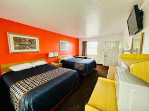 Habitación de hotel con 2 camas y paredes de color naranja en GreyStone Inn, en Bridgeport