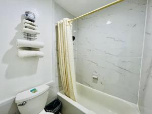 y baño con ducha, aseo y toallas. en GreyStone Inn, en Bridgeport