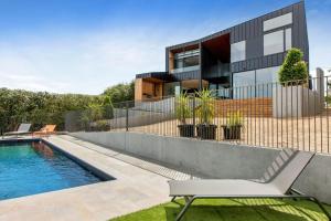 a house with a swimming pool in front of it at COASTAL LUXE MT MARTHA in Mount Martha