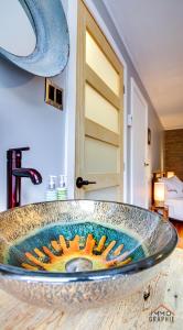 - un lavabo dans la salle de bains avec un bol en verre sur un comptoir dans l'établissement Maison Cadorette, à Saint-Jean-des Piles