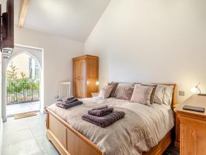 1 dormitorio con 1 cama grande y toallas. en Bell House Stables - Uk41789 en Melton Constable