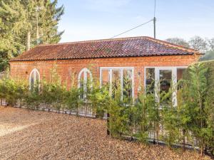 a red brick greenhouse with plants in front of it at Bell House Stables - Uk41789 in Melton Constable