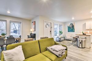 ein Wohnzimmer mit einem grünen Sofa und einer Küche in der Unterkunft Stylish Retreat with Yard Less Than 5 Mi to MSU Campus in Lansing