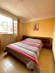 1 dormitorio con 1 cama en una habitación con ventana en Vila Festiva Cochabamba céntrica, en Cochabamba