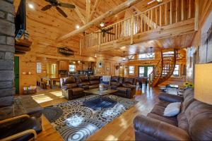 a living room with leather furniture in a log cabin at The Eastwood Spacious Retreat with 4 King En-Suites - Hot Tub - Pet-Friendly - Cozy Fire Pit - Prime Location - Multi-Family in Broken Bow