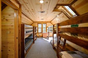 a room with several bunk beds in a cabin at The Eastwood Spacious Retreat with 4 King En-Suites - Hot Tub - Pet-Friendly - Cozy Fire Pit - Prime Location - Multi-Family in Broken Bow