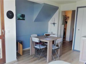 a dining room table with chairs and a blue wall at Appart Duplex 8 pers avec Terrasse à Pra-Loup - FR-1-165A-170 in Uvernet-Fours